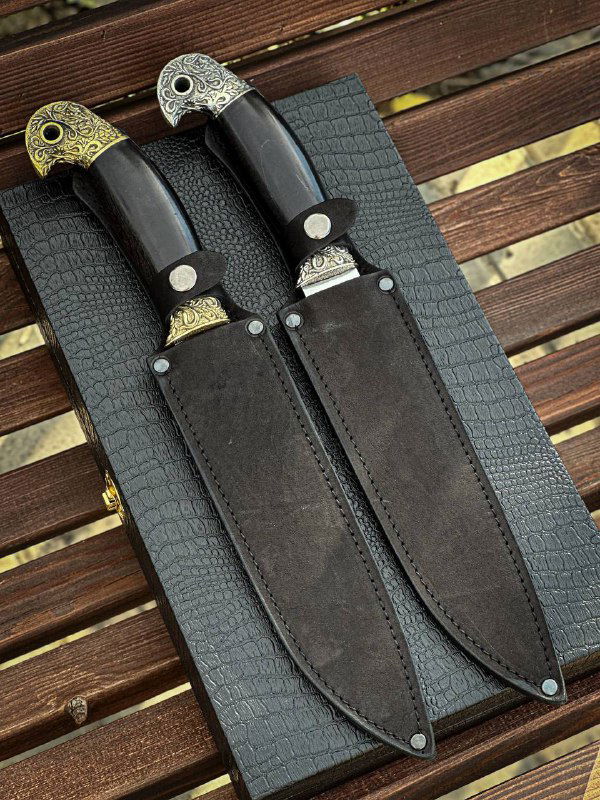 Два сложенных ножа «Пластунский» в кожаных ножнах, вид на лицевую сторону ножен и фиксирующие заклепки.