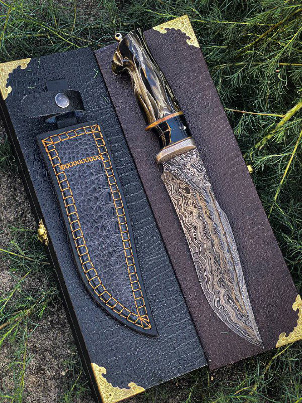 Вид сверху на нож «Американец»: рисунок кручёного дамаска, детали гарды с рогом индийского буйвола и яркая отделка рукояти макуме-гане.