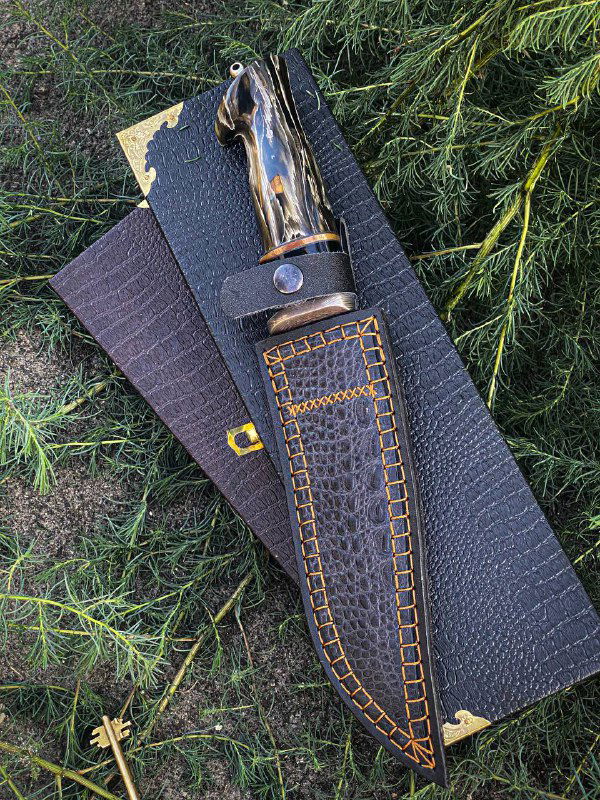 Фрагмент рукояти ножа «Американец»: макуме-гане с полировкой и текстурой, виден ремешок на ножнах и декоративные элементы.