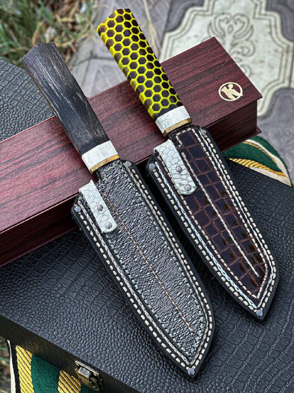 Ножи в ножнах на деревянном бруске: акриловая рукоять с узором сот, вставка рога лося и аккуратная отделка кожаных ножен.