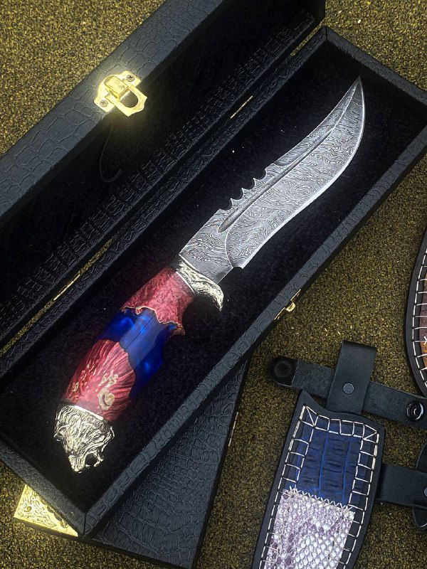 Нож «Лев» в подарочной коробке: дамасковый клинок и рукоять из акрила красно-синего цвета, рядом видна оформленная кожаная ножна.