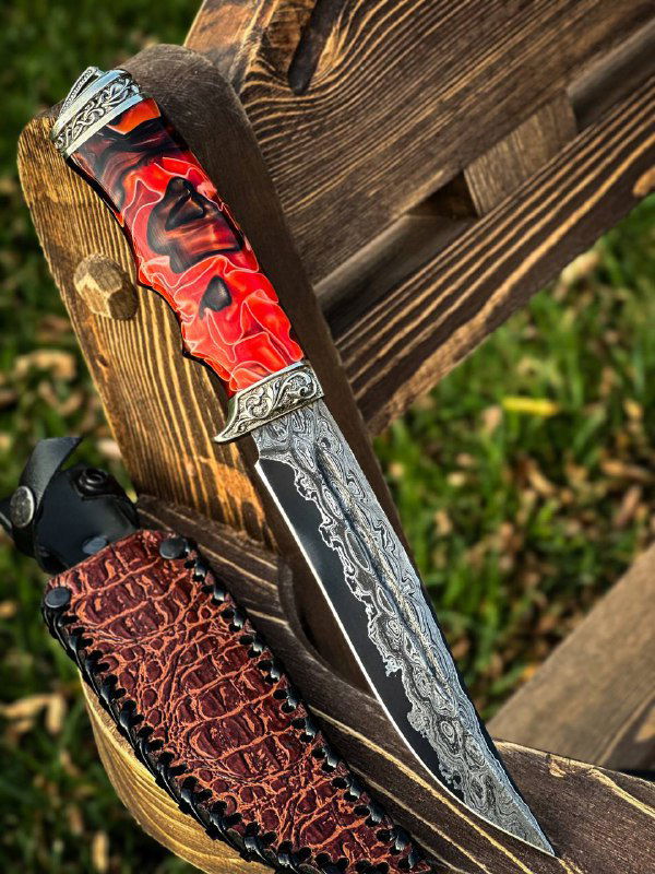 Детальный план клинка и рукояти: яркий акрил, чёткий дамасковый рисунок на лезвии и декоративные мельхиоровые вставки, ножны частично видны.