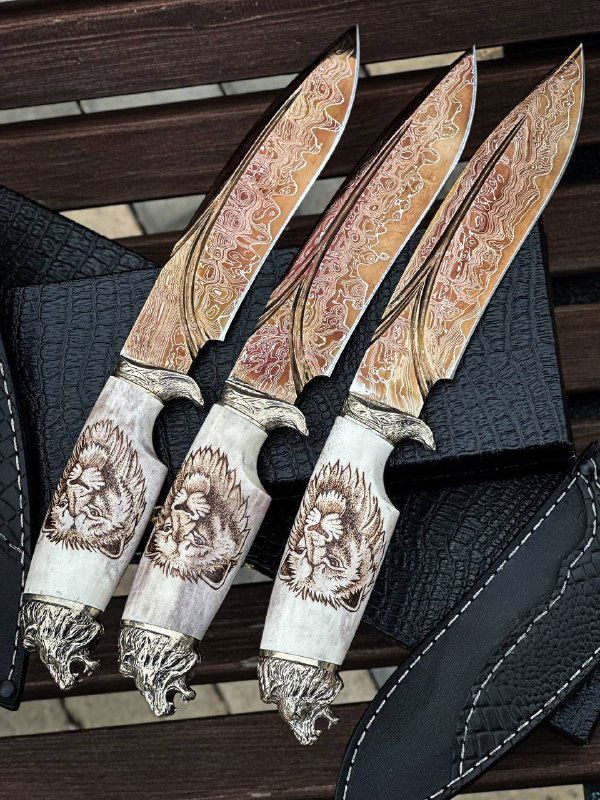 Детальный вид клинков: рисунок дамаска с разноцветным оксидированием, видны сходные мотивы и оформление рукоятей из рога.