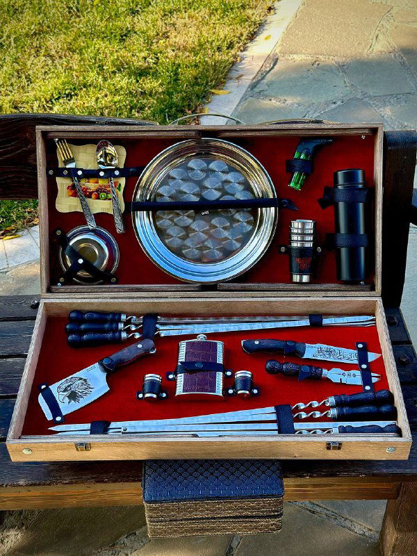 Полный вид открытого кейса с красной подкладкой: шампуры, мангал, ложки, фляжка и туристический нож — всё уложено аккуратно.