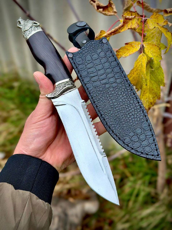Нож «Волк» с кожаными ножнами: полный комплект на руке владельца, ножны чёрной фактуры и вид клинка в сборе на фоне осенних листьев.