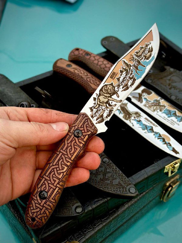 Крупный план лезвия и плашки разделочного ножа: резной узор на дереве и сложная многоцветная гравировка на стали.