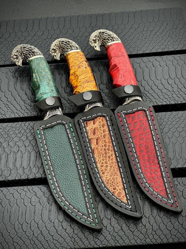Три кожаных ножна разных цветов под ножи «Орлан»: зелёные, коричневые и красные с декоративной прострочкой на тёмном фоне.