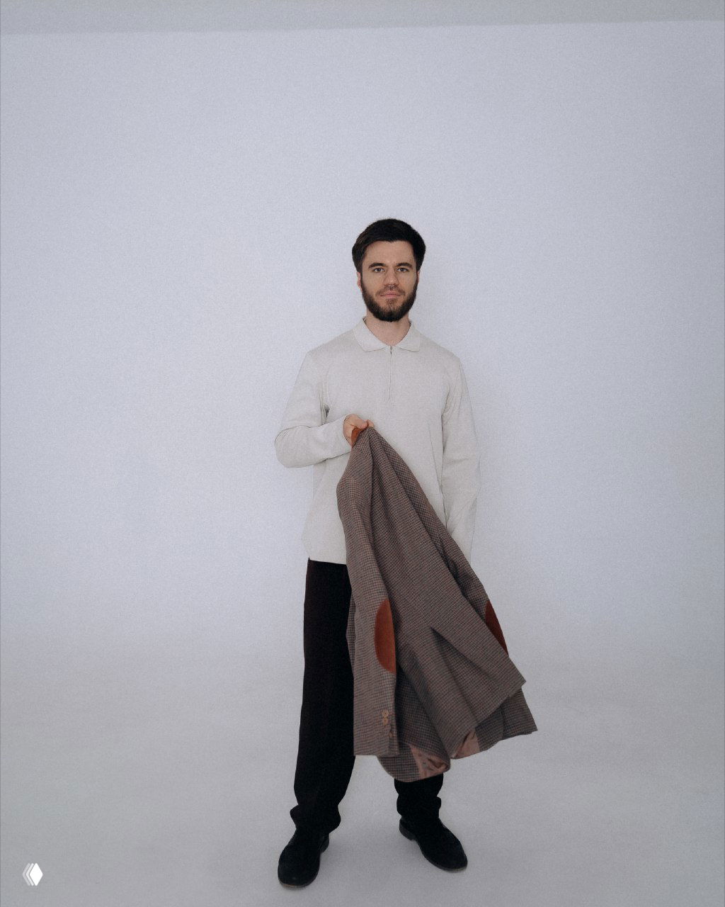 Мужчина в светлой рубашке стоит на белом фоне и держит пиджак в руке; нейтральный портрет, иллюстрация к посту о контент-воронке и продажах.