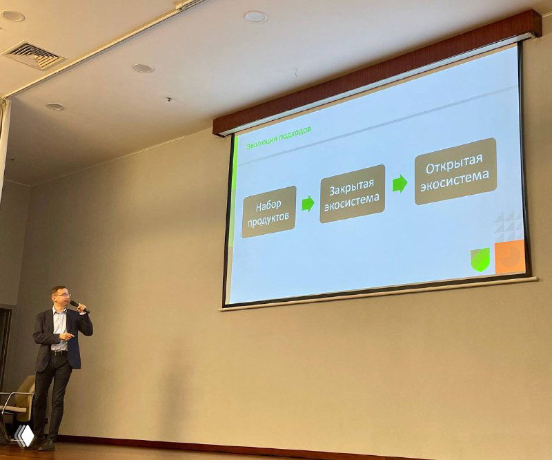 Спикер на партнёрской конференции у проекционного экрана со слайдом об эволюции экосистем кибербезопасности и партнёрствах вендоров.