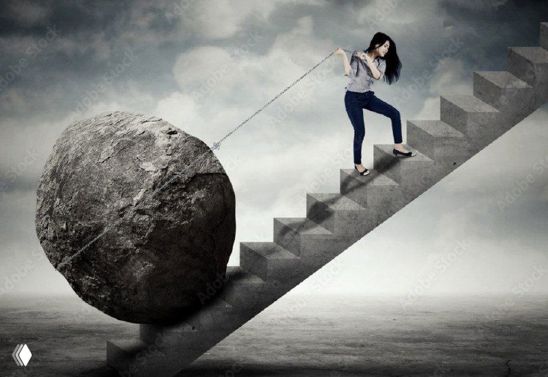 Женщина тянет валун вверх по лестнице — метафора борьбы и необходимости отпустить старые роли ради трансформации.