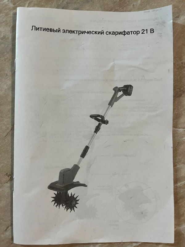 Фотография развёрнутой страницы инструкции с иллюстрацией и заголовком «Литиевый электрический скарификатор 21 В», лист бумаги лежит на столе.