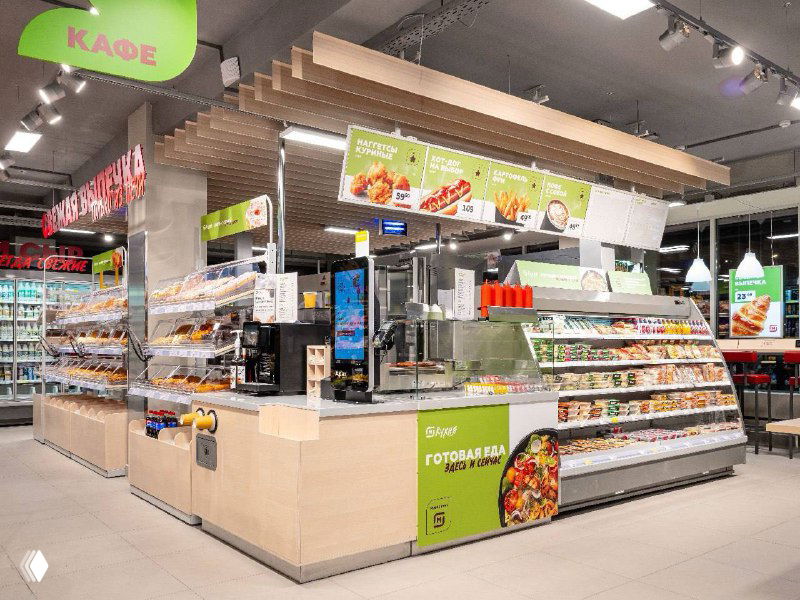 Интерьер нового компактного формата «Заряд от Магнита»: стойка с готовыми блюдами, витрины, профессиональное оборудование и уютная зона для гостей в магазине.
