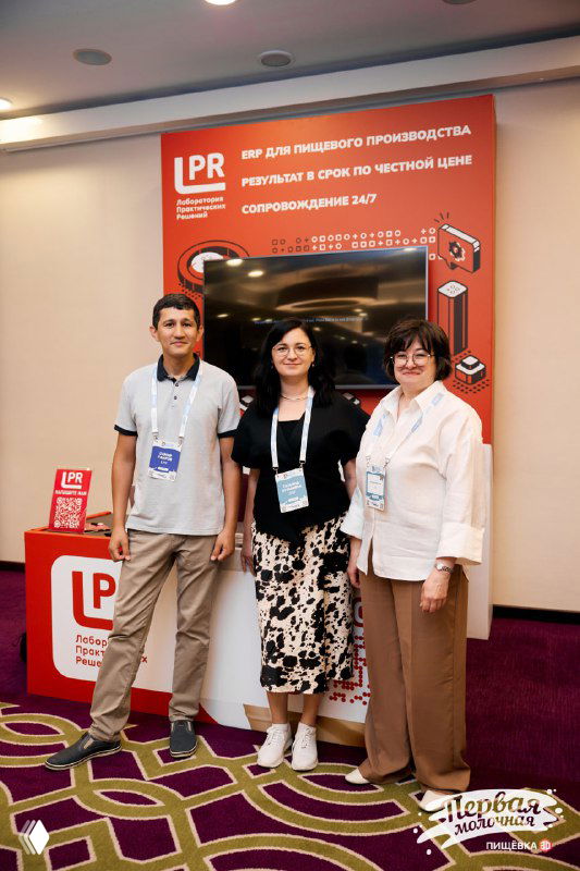 Три представителя ЛПР у красного бренд‑стенда на конференции Пищёвка3D: деловая обстановка, логотип и экран с информацией о решениях.