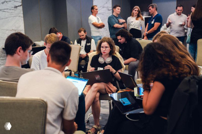 Teams working in a meeting area with laptops and whiteboards: groups of young founders developing concepts and prototyping during the hackathon.