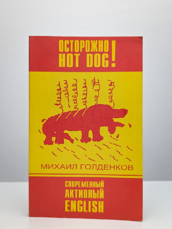 Обложка книги Михаил Голденков «Осторожно Hot Dog!»: яркая жёлто‑красная обложка, книга о современном активном английском и практических приёмах изучения языка.