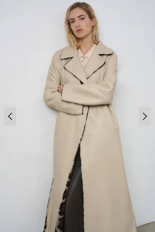 Светлое бежевое пальто средней или длинной длины на модели, классический прямой крой — универсальный нейтральный элемент капсулы.