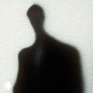 Размытый силуэт человека в тени на зернистом фоне, абстрактный образ подавленной внутренней Тени и скрытой эмоциональной боли.
