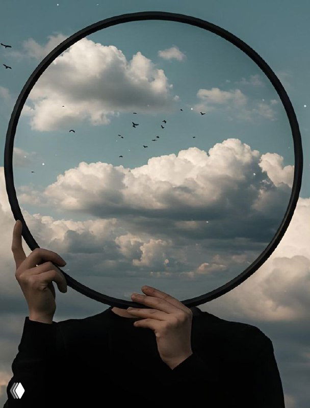 Руки человека держат круглый ободок с отражением неба и облаков; силуэт без лица на фоне птиц — метафора внутреннего отражения, тени и самопознания.
