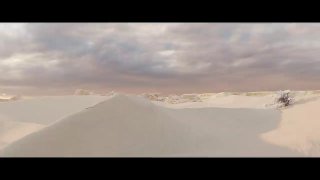 Панорамный кадр с песчаными дюнами и пасмурным небом, широкий пустынный пейзаж из ролика, создающий ощущение масштаба сцены.