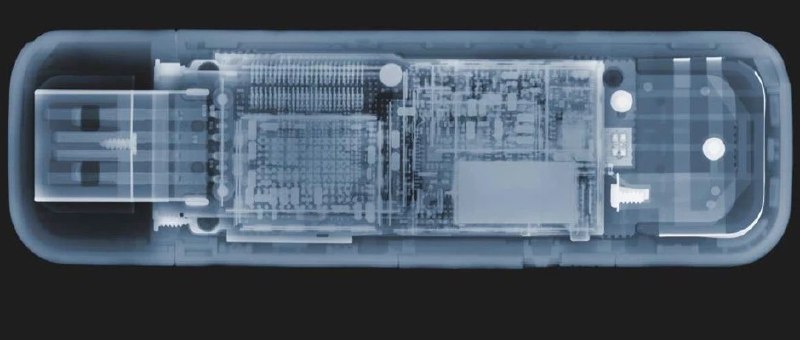 Рентгеноподобное изображение USB‑накопителя с видимой платой и компонентами, показывающее внутреннюю структуру устройства.