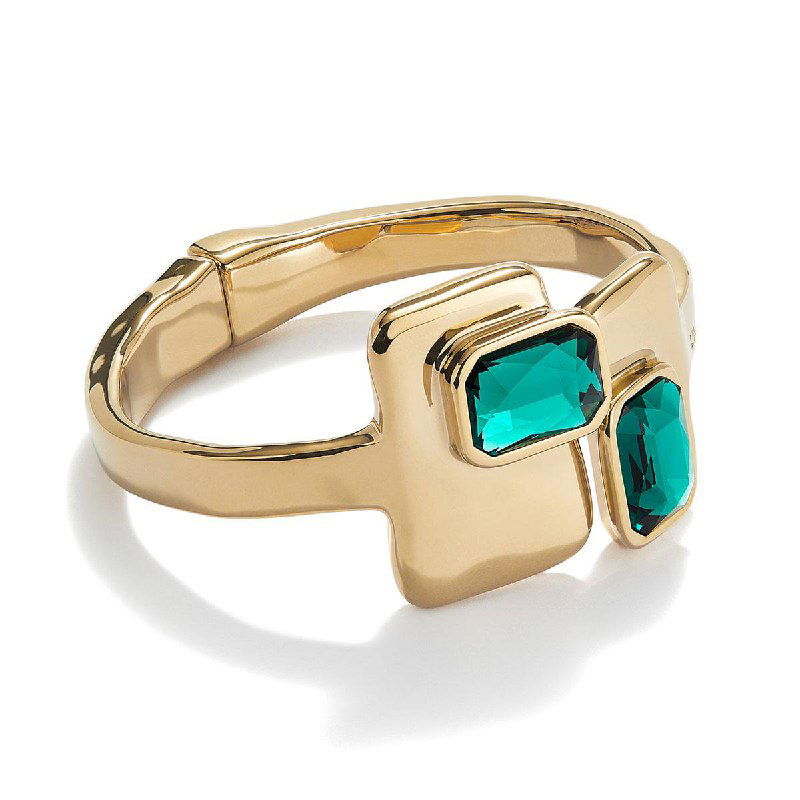 Товарная фотография золотистого кольца с двумя зелёными прямоугольными кристаллами — детальный вид ювелирного изделия.