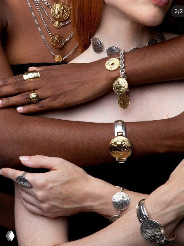 Несколько рук разного тона кожи в украшениях с монетами и кольцами — показ разнообразия сочетаний коллекции на моделях с разной внешностью