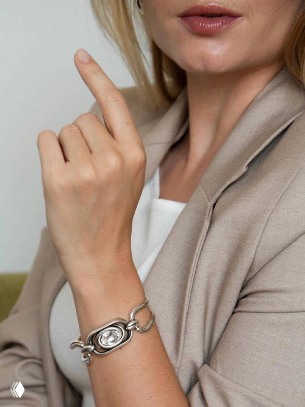 Крупный план запястья и браслета CICLON из сплава ZAMAK с круглой декоративной пластиной и элегантной текстурой металла на светлом фоне.