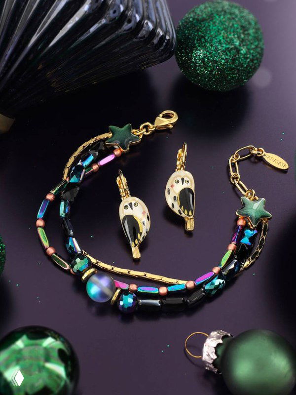Комплект TARATATA: браслет и серьги с разноцветными бусинами и металлическими элементами на тёмном фоне с зелёными декоративными шарами.