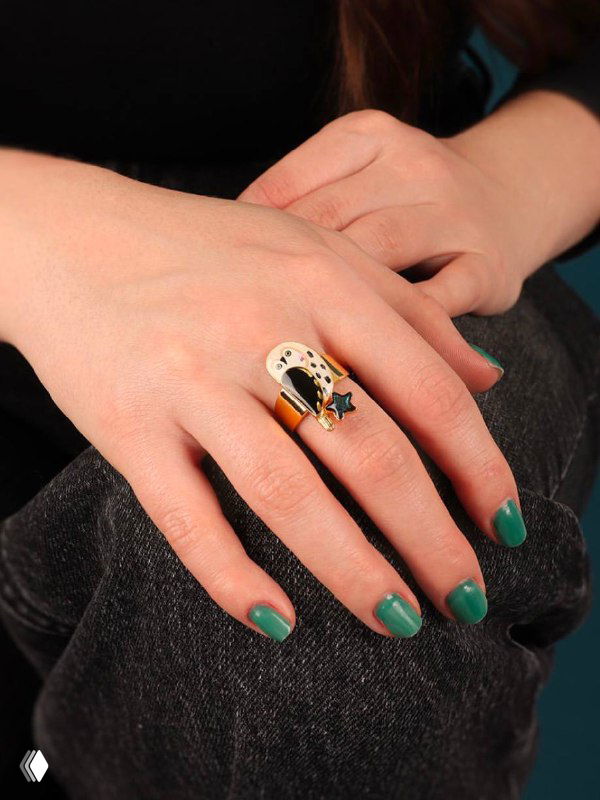 Кольцо TARATATA на руке модели: демонстрация посадки украшения на пальце, эмаль и золотистое покрытие подчёркивают дизайн.