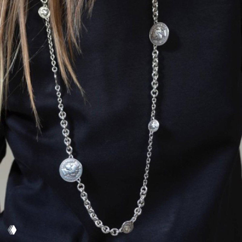 Длинное цепочное колье с несколькими декоративными монетами, надетое на темную одежду модели для показа длины и фактуры украшения.
