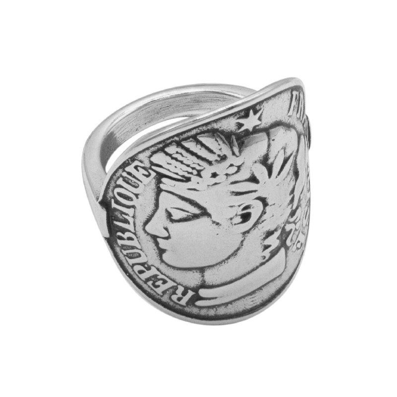 Кольцо с рисунком монеты в серебристом цвете, крупный план изделия показывает тиснение и форму оправы кольца.