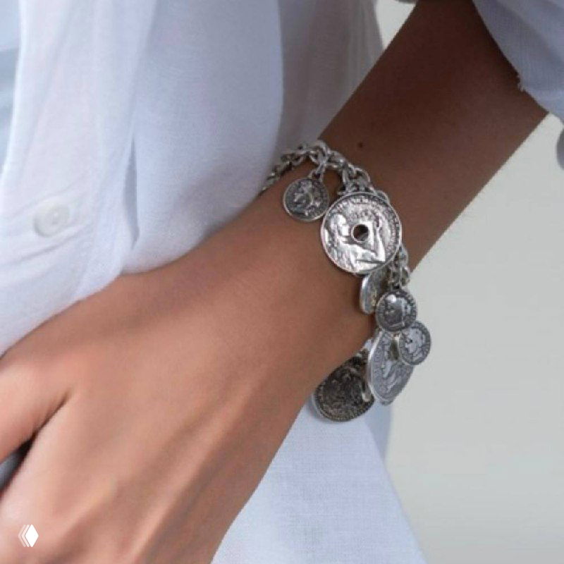 Браслет с множеством небольших монет-подвесок на запястье модели, стильная многомонетная деталь в образе коллекции FRANCE.