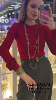 Модель в красном свитере демонстрирует длинное колье-цепь Fiore di Firenze в интерьере ювелирного магазина, виден боковой ракурс.