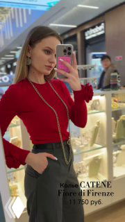 Женщина делает селфи у витрины магазина Rosone, на ней несколько золотых цепочек Fiore di Firenze разной длины и фактуры.