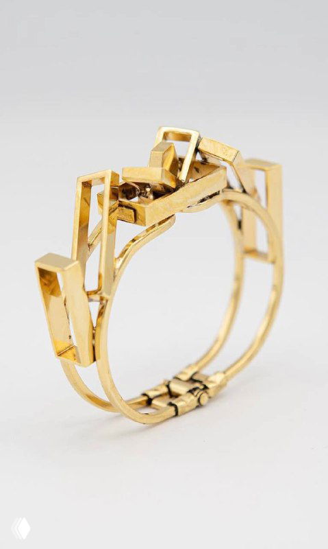 Золотистый браслет/клипс Claudio Canzian: геометрический металлический дизайн с аккуратным замком, крупный план на светлом фоне.