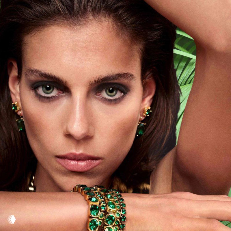 Крупный портрет модели с браслетом Dyrberg Kern из зелёных камней — акцент на текстуре украшения и эффектном макияже для праздничного лука