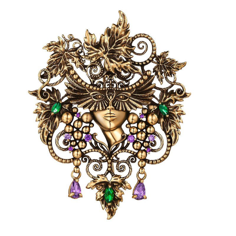 Декоративная брошь Fiore di Firenze с богатым орнаментом, маскообразный центральный мотив и зелёные с фиолетовыми вставки, подробный съёмочный ракурс на белом фоне.