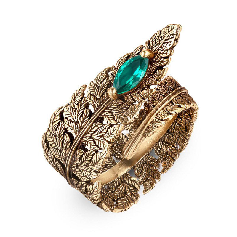 Широкое кольцо Fiore di Firenze с рельефным рисунком перьев и крупным зелёным камнем-кабошоном, антик-золотистая отделка, крупный план на белом фоне.