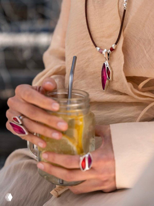 Подвеска и кольцо Ciclon с розовыми вставками муранского стекла в руках у модели, демонстрация комбинации украшений с повседневным образом