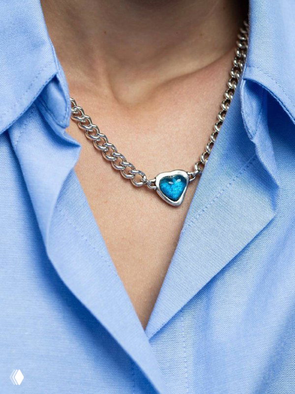 Крупное колье с сердцевидной голубой вставкой муранского стекла на фоне голубой рубашки, акцент на форму и насыщенность цвета