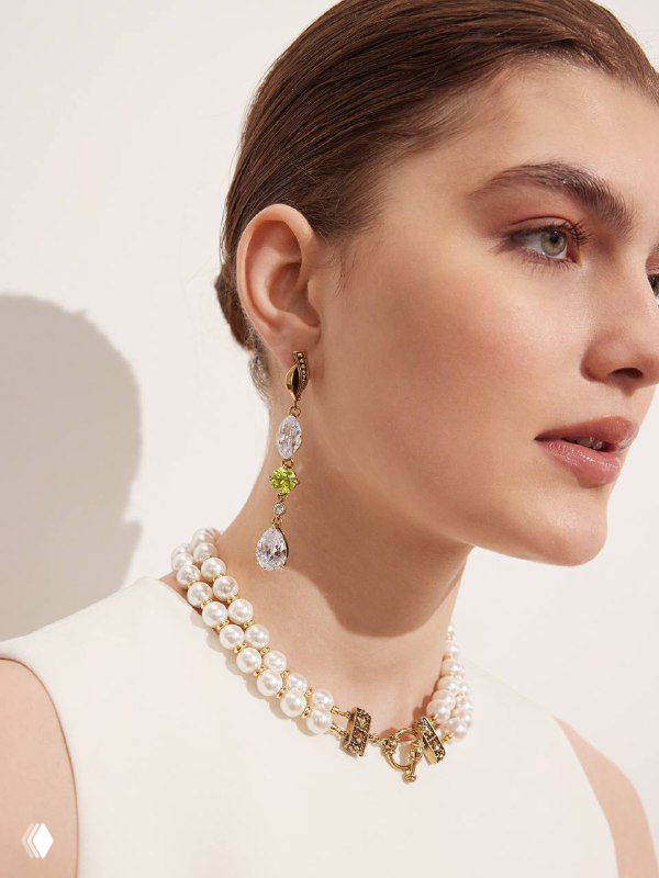 Профиль модели с длинными сияющими серьгами и жемчужным ожерельем Fiore di Firenze; студийная съёмка каталога Rosone, акцент на форме и блеске украшений.