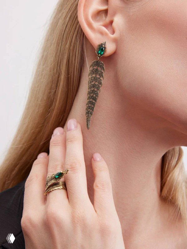 Крупный план уха и руки с серьгой и кольцами Fiore di Firenze с зелёной вставкой; фотосъёмка каталога Rosone, внимание к камням и отделке металла.