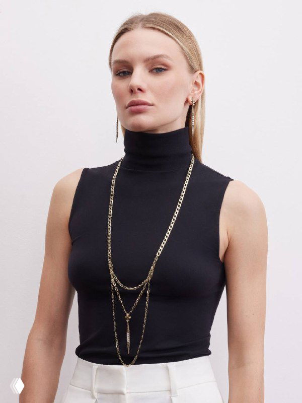 Фотография модели в полный рост в черном топе с длинными золотыми цепями и украшениями IL SPADA, стильный образ для витрины магазина Rosone.