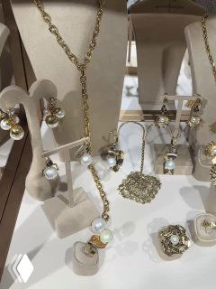 Фотография демонстрационной группы серьг, колье и колец на белом фоне — подборка классической бижутерии с жемчужными и золотистыми акцентами.