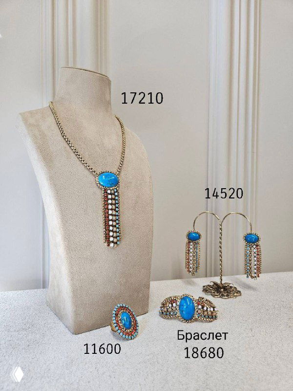 Набор бирюзовых украшений Claudio Canzian: колье, серьги и браслет на бежевых подставках с указанием цен и артикулов на фото.