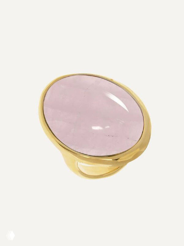Крупный план золотого кольца VIDDA с овальным розовым полудрагоценным камнем на нейтральном светлом фоне, подчёркнута текстура металла