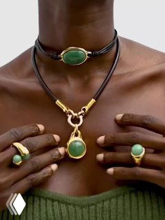 Модель демонстрирует колье и перстни VIDDA: зелёные камни и золотая фурнитура в составе комплекта, студийная съёмка для каталога