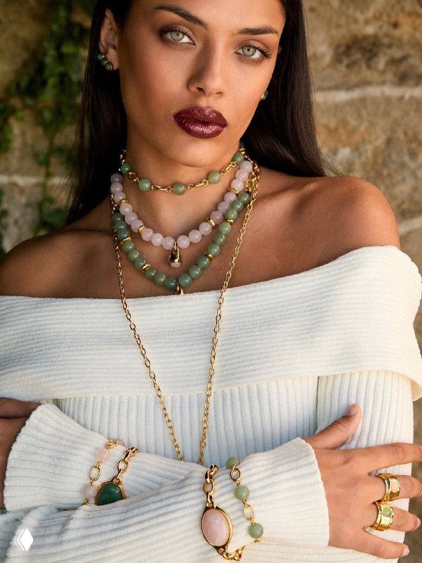 Портрет модели в светлом свитере с несколькими ожерельями VIDDA из зелёных и розовых камней — демонстрация сочетаний аксессуаров