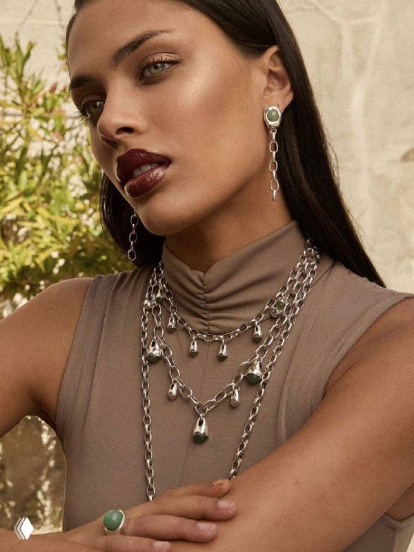 Портрет модели с серебристыми многослойными цепями и серьгами VIDDA — акцент на текстуре металла и модной слоистости украшений
