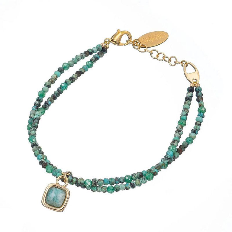 Тонкий двойной браслет Lanzerotti из мелких бирюзовых и зелёных бусин с изящной подвеской в металлической оправе на белом фоне.